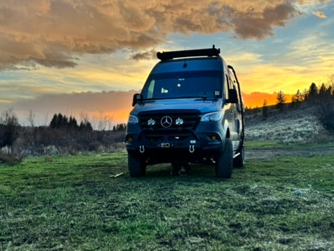 winnebago revel in a pnw field near mountains in washington after suspension and bumper upgrade