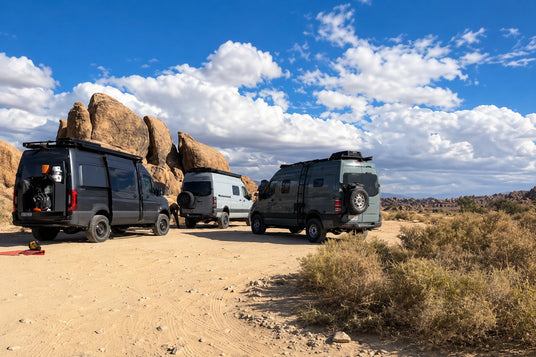Adventure vans gathered beside desert boulders during a Wolf Pack trip