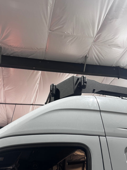 Two cameras mounted on the upper rack of a white adventure van