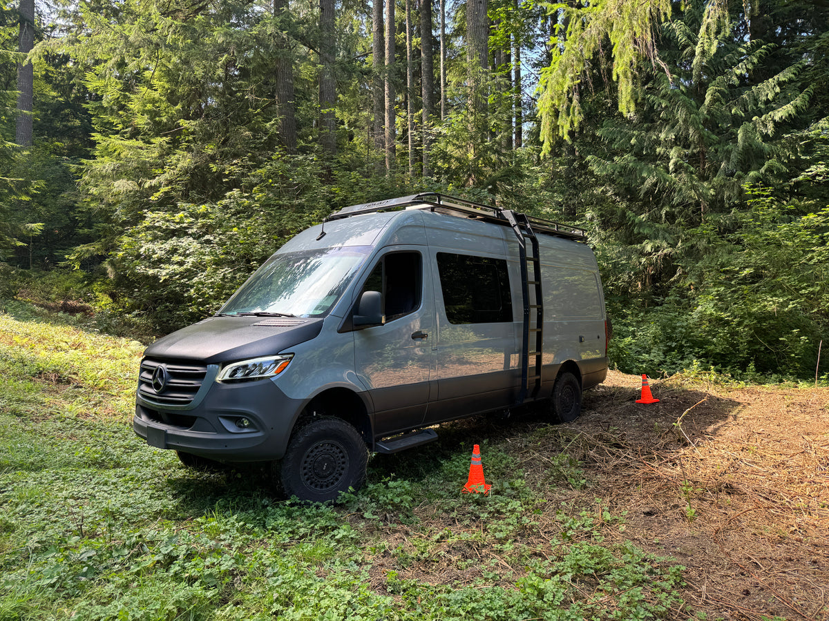 A Sprinter adventure van practicing on a course marked with cones in the forest