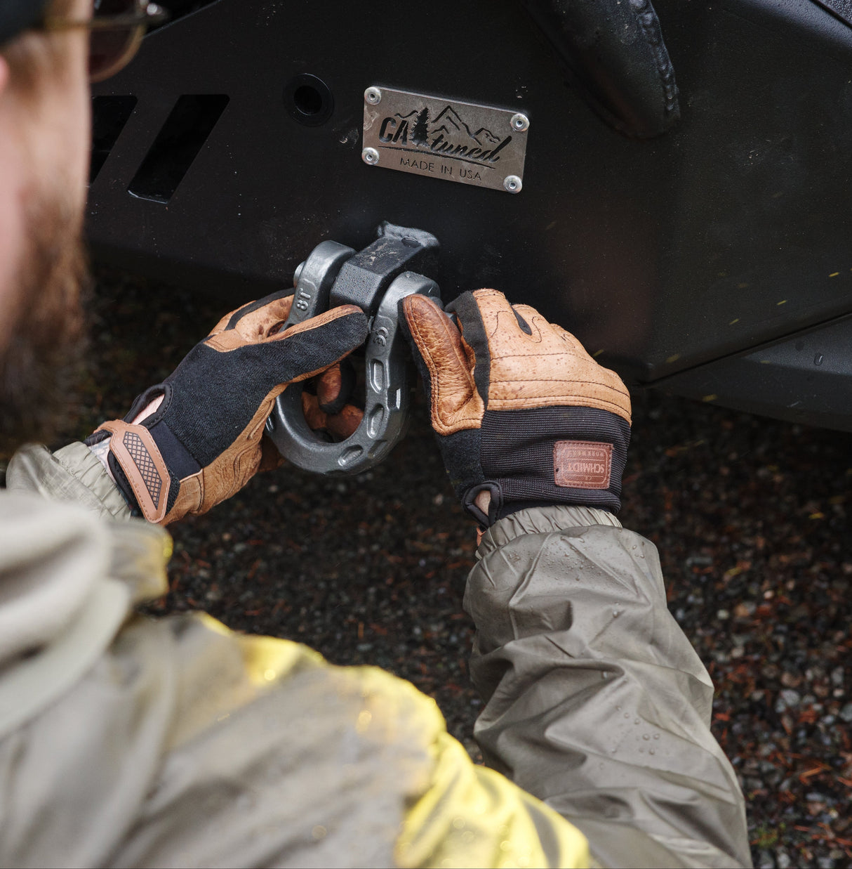 Person attaching a hitch to a vehicle with a close-up of the action.