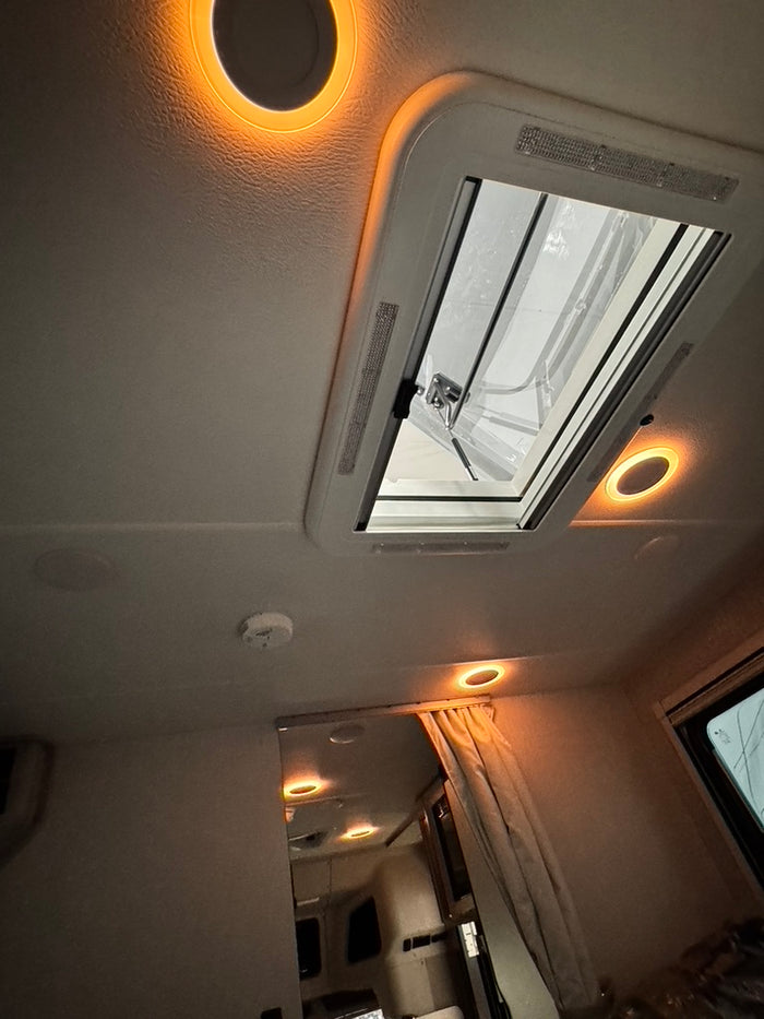 Warm amber interior ceiling lighting in a Winnebago Ekko